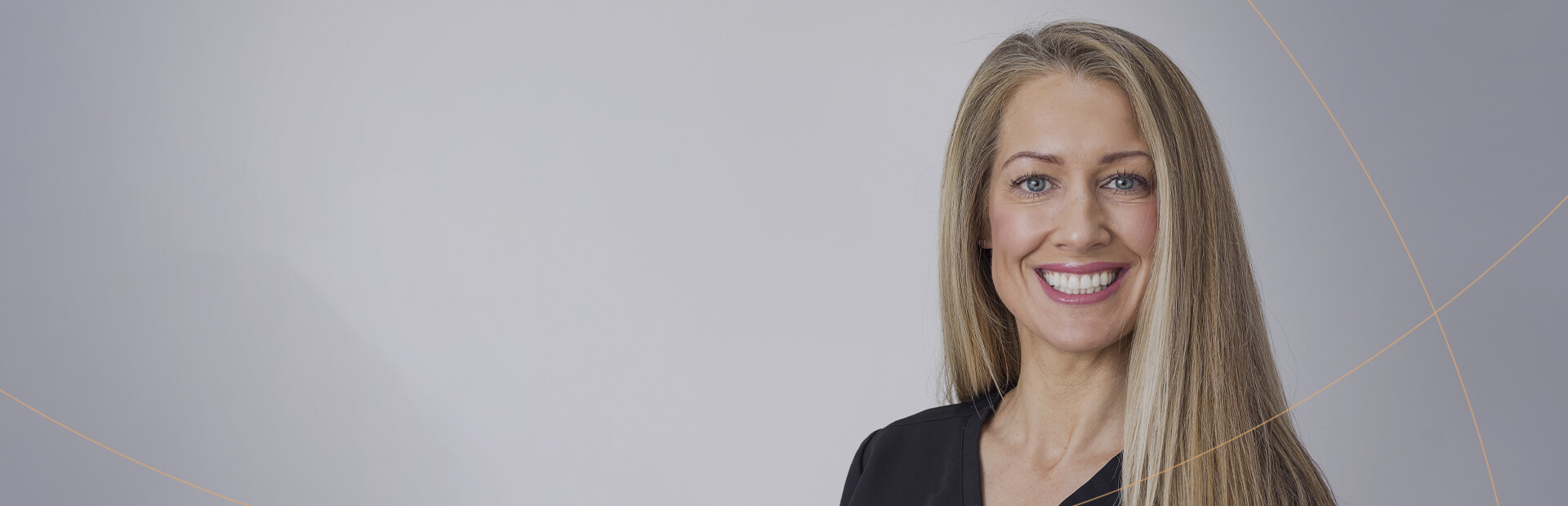 A portrait of a woman in black dental scrubs, smiling brightly with long blonde hair. She is part of the Smile HQ.