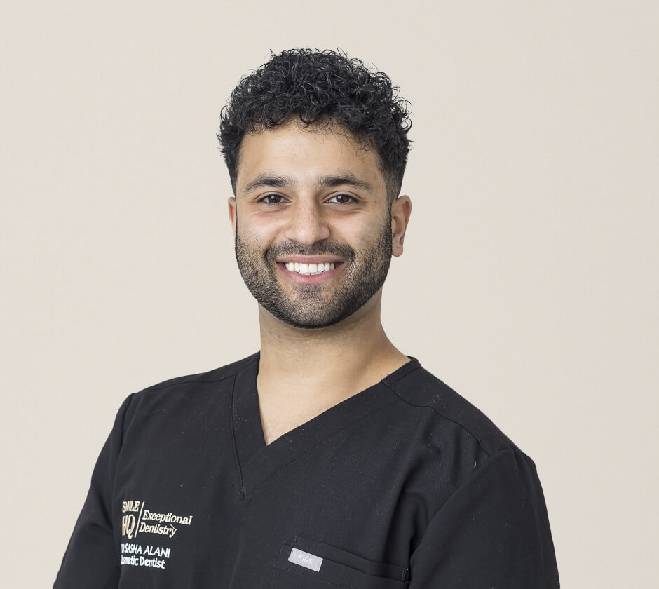 Portrait of a cosmetic dentist smiling while wearing a black dental scrub.