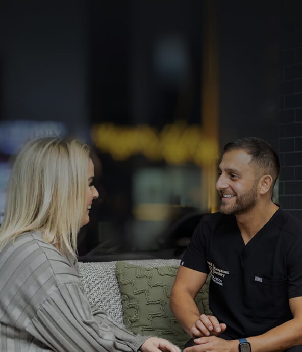Image of a dentist and a patient having a conversation, with both smiling during the consultation at Smile HQ Exceptional Dentistry.