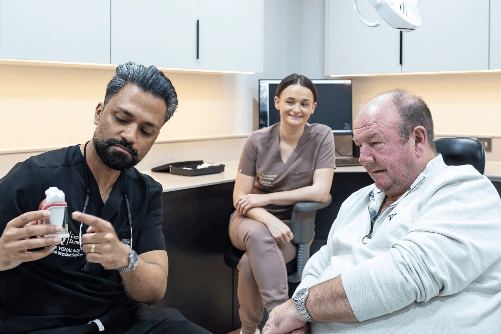 Implant Surgeon Dr Vishal Patel explaining dental implant treatment options during a consultation